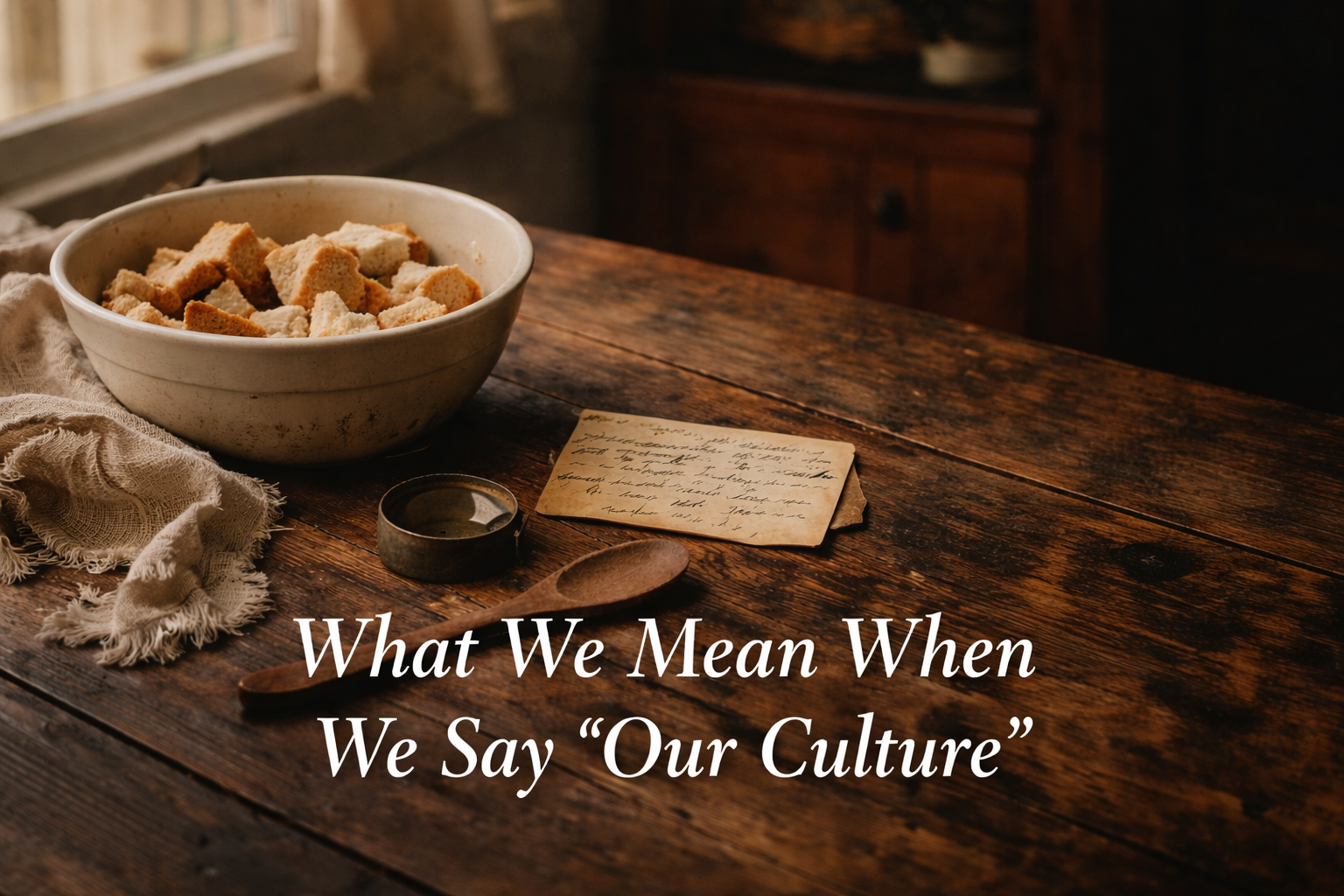 A quiet kitchen scene with a wooden table and food preparation, suggesting memory, care, and cultural continuity.