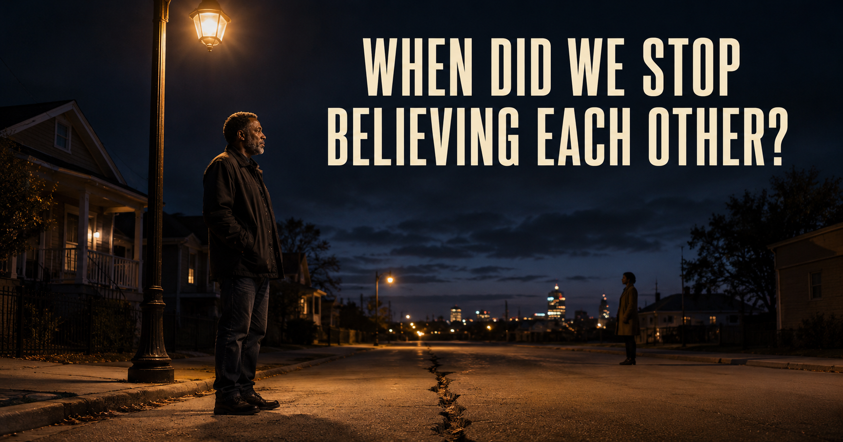 A Black man standing beneath a streetlight and looking toward another person across a quiet divide.