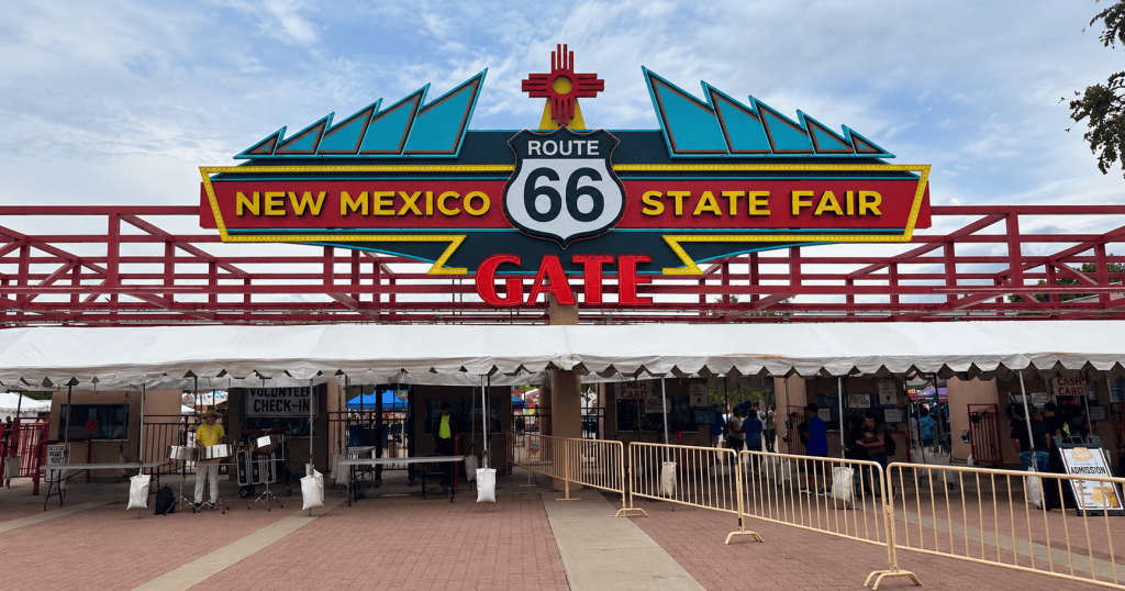 New Mexico State Fair entrance with a Route 66 sign beneath a cloudy sky.