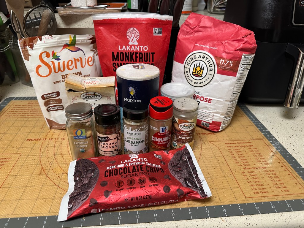 Ingredients for sugar-free pumpkin chocolate chip bread, including flour, monk fruit sweetener, spices, and sugar-free chocolate chips.